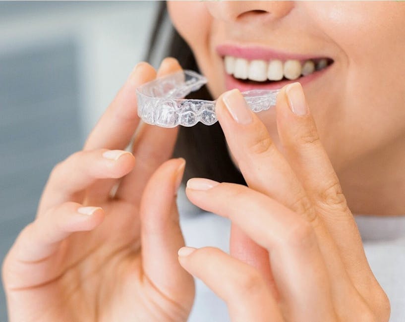 Patient holding a clear dental aligner before fitting