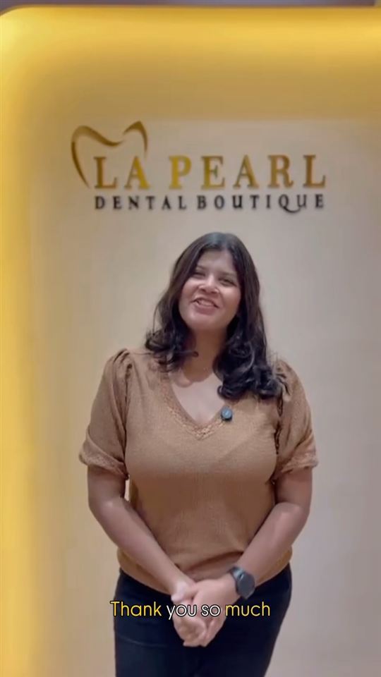 A patient at La Pearl Dental Boutique sharing her experience after treatment